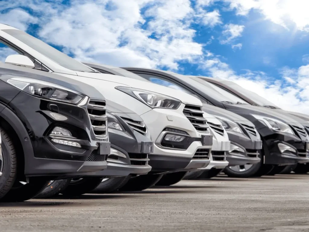A row of SUVs parked on a dealership lot under a clear blue sky