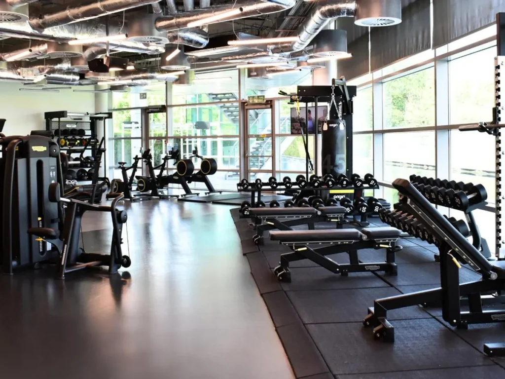 Modern gym floor with weight benches, dumbbells and weight racks