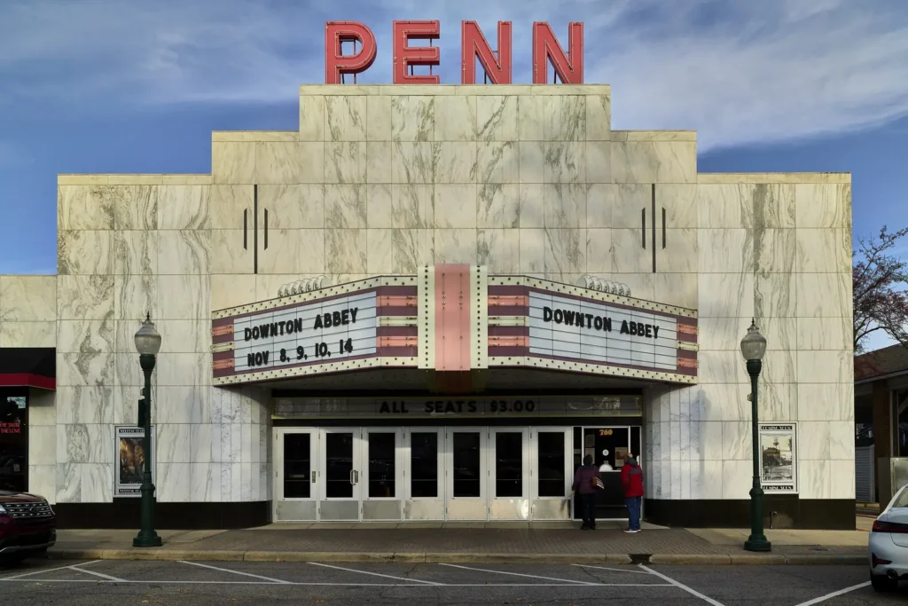 The white marble Art Moderne facade of the Penn Theatre with its red PENN sign and marquee on Penniman Avenue in downtown Plymouth, Michigan